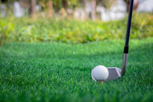 Golfball aus nächster Nähe auf dem Abschlagrasen vor verschwommener, wunderschöner Golflandschaft im Hintergrund. Internationales Konzept