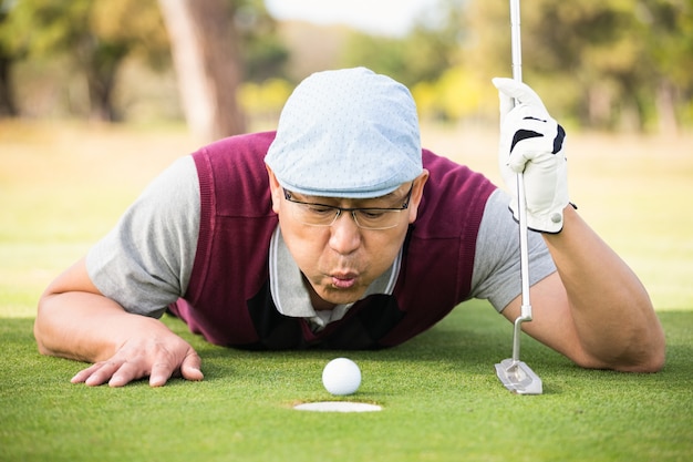 Golfer bläst Ball in das Loch