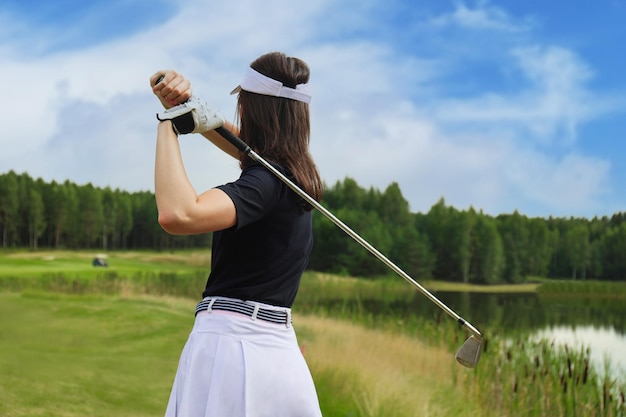 Golferin schlägt einen Fairway-Schuss in Richtung Clubhaus.