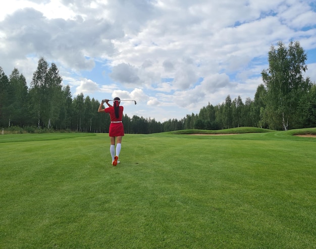 Golferin schwingt Club auf dem Golfplatz