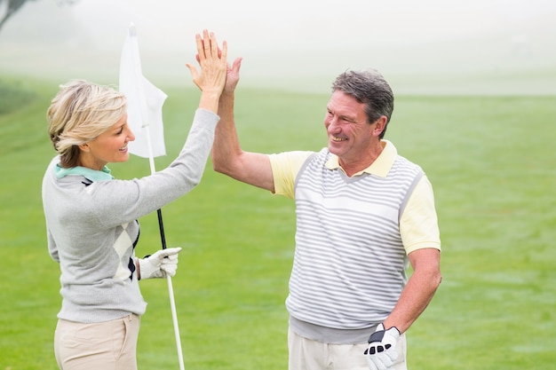 Golfing pareja alto fiving