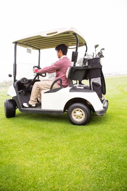 Foto golfista conduciendo en su carrito de golf