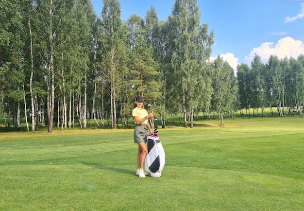 Golfista de mulher bonita segurando um saco de golfe