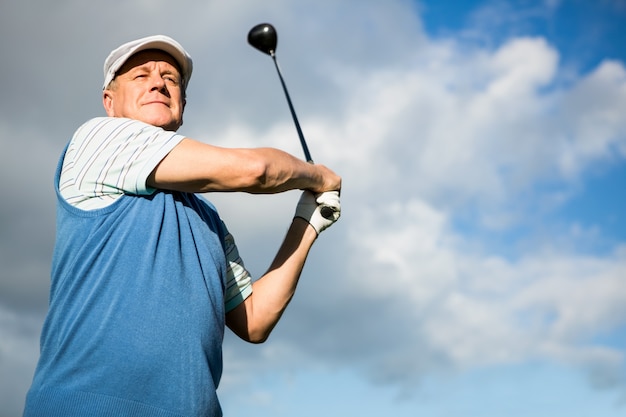 Foto golfista em pé e balançando seu clube