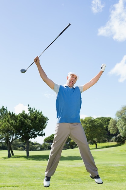 Golfista emocionado saltando y sonriendo a la cámara