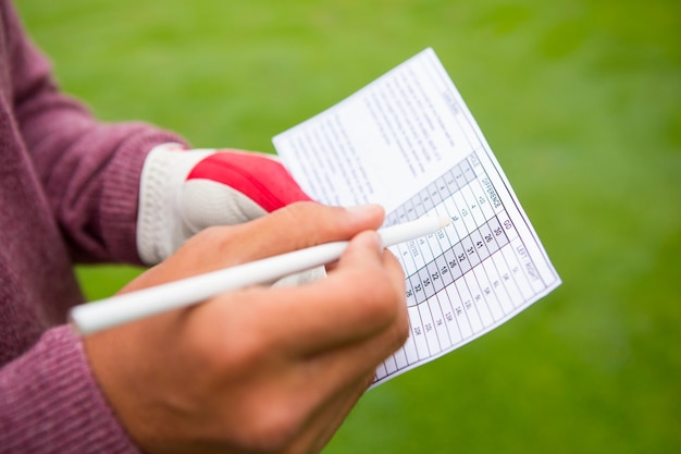 Golfista escribiendo sus puntos en papel