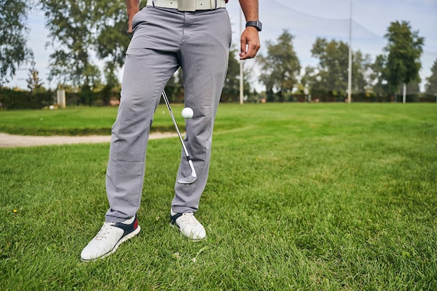 un golfista experimentado que utiliza su palo de golf para mejorar la técnica del juego