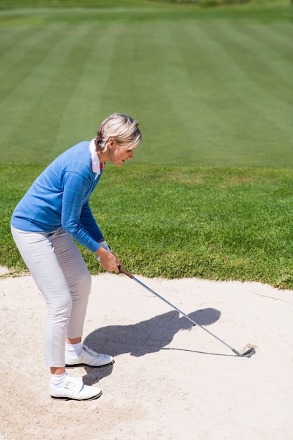 Golfista femenina que toma un tiro