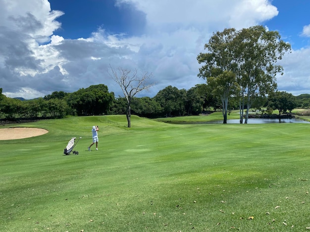 Golfista golpea con palo en campo de golf