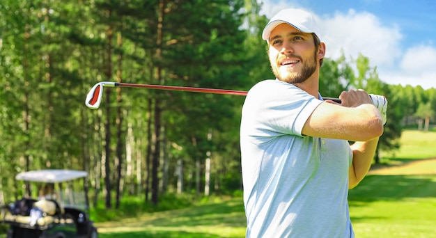 Golfista golpeando tiro de golf con el club en curso mientras que en vacaciones de verano