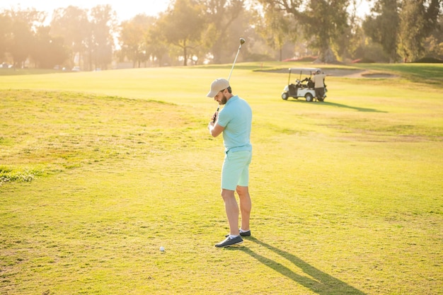 Golfista en gorra con club de golf gente estilo de vida hombre jugando en hierba verde