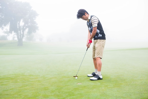 Golfista en el green en el hoyo