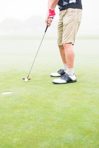 Golfista en el putting green en el hoyo