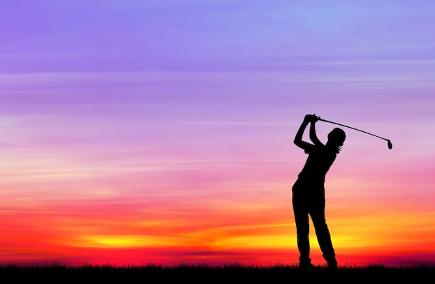 Foto golfista silueta jugando al golf durante la hermosa puesta de sol