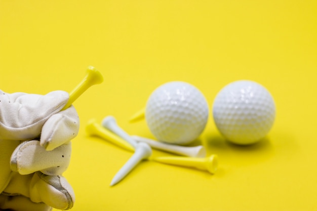 Foto golfista está sosteniendo tees de golf sobre fondo amarillo