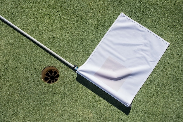 Golfplatz mit leerem Loch und weißer Flagge