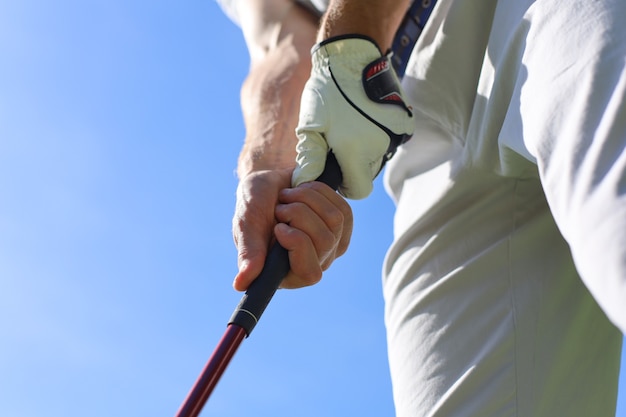 Golfspieler, der einen Golf mit einem Putter trägt.