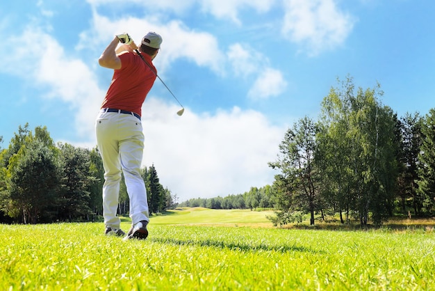 Golfspieler, der Golf schlägt, schoss mit Verein auf Kurs während auf Sommerferien