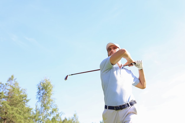 Golfspieler, der im Sommerurlaub Golf mit Schläger auf Kurs schlägt.