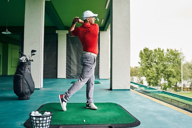 Golfspieler mit einem Schläger in der Hand, der in die Ferne steht