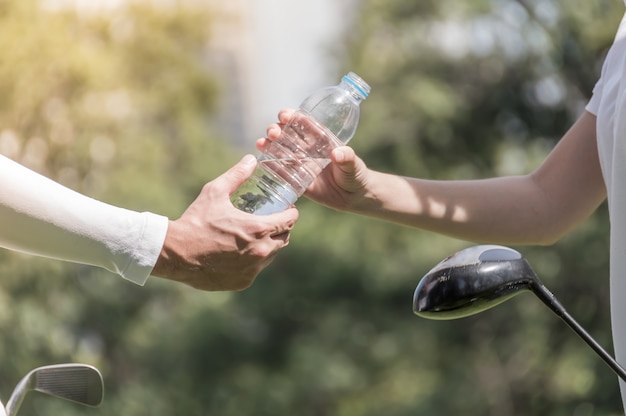 Golfspieler verteilten Trinkwasserflaschen an Teamkollegen
