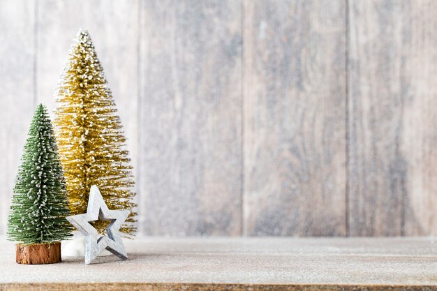 Golg und grüner Weihnachtsbaum auf einem hölzernen Hintergrund.