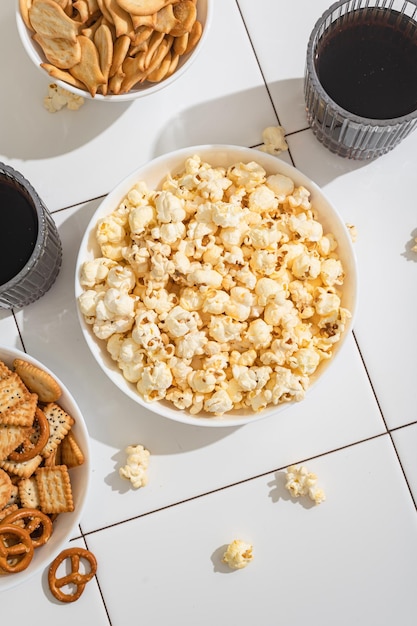 Golosinas caseras comida rápida un tazón con galletas de palomitas de maíz y galletas en una mesa blanca