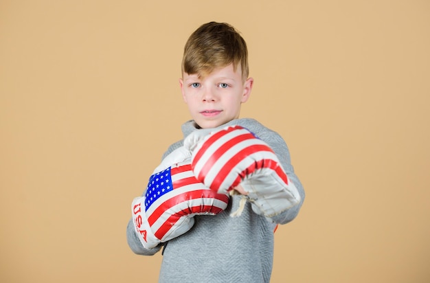 Golpe de gracia Entrenamiento de actividad infantil de boxeador de niño pequeño Éxito deportivo Confiado en su régimen de fitness energía salud día de la independencia de estados unidos Niño feliz deportista en guantes de boxeo