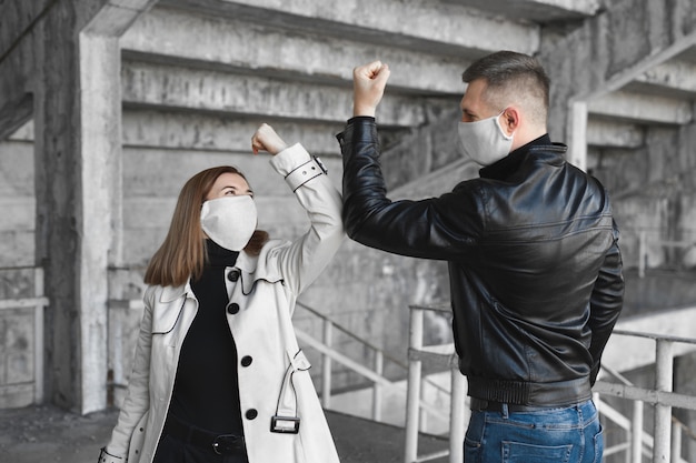 Golpes en el codo. Una nueva forma de saludo para evitar la propagación del coronavirus, covid19. Un hombre y una mujer se golpean los codos en lugar de abrazarse o apretarse las manos