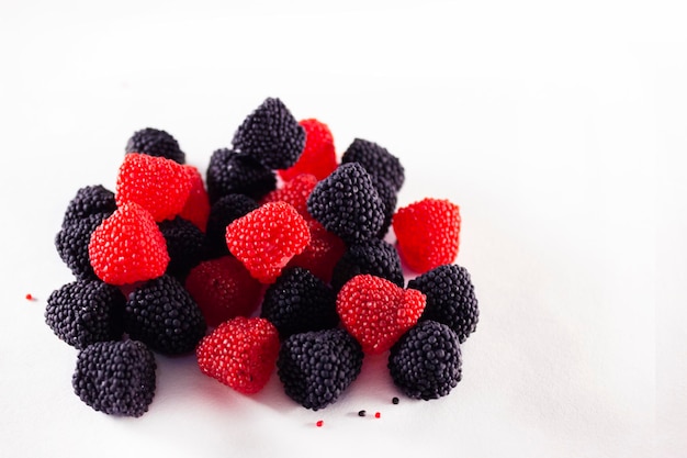 Gomitas de frutas arándano y fresa fondo blanco.