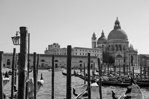 Gondeln und die Kirche Santa Maria della Salute über den Canal Grande in Venedig, Italien. Schwarz-weißes venezianisches Stadtbild