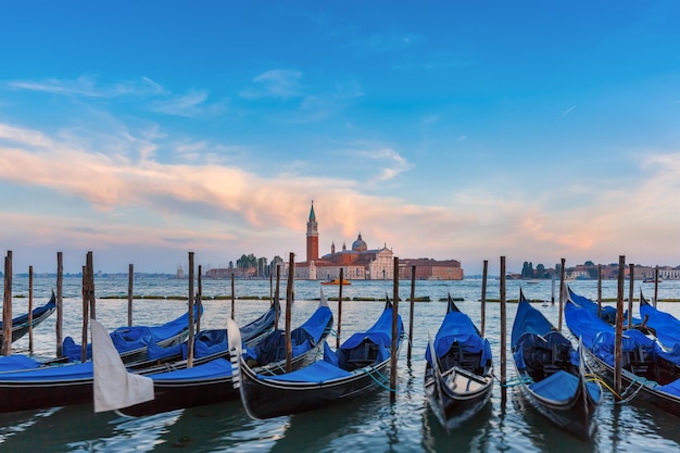 Gondeln vertäut am Markusplatz mit der Kirche San Giorgio di Maggiore im Hintergrund am Abend, Venedig, Italia