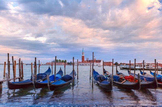 Las góndolas amarradas por la plaza de San Marcos con la iglesia de San Giorgio di Maggiore en el fondo durante la hora azul del crepúsculo Venecia Italia