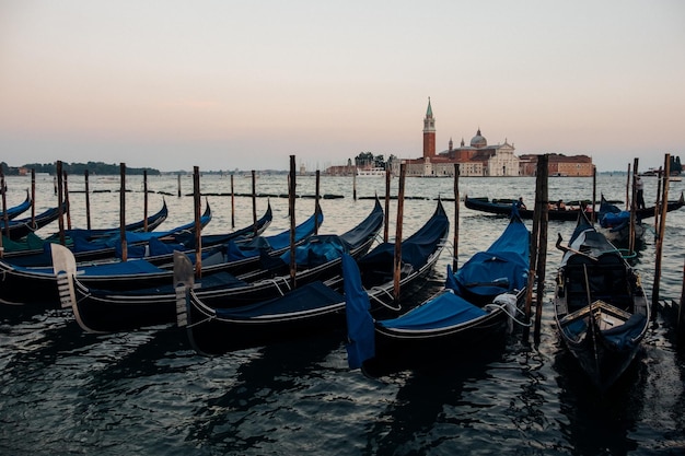 Gondolas ancoradas no mar durante o pôr-do-sol