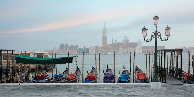 Gôndolas e igreja de san giorgio di maggiore ao amanhecer no nevoeiro veneza italia