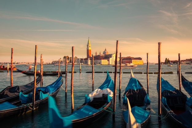 Gôndolas estacionadas em Venezia com a igreja de San Giorgio Maggiore nos fundos, Veneto, Itália.