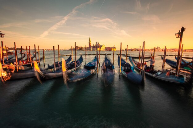 Gôndolas estacionadas em Venezia com a igreja de San Giorgio Maggiore nos fundos, Veneto, Itália.