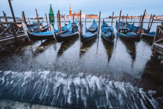 Góndolas flotando en el Gran Canal en la cálida luz de la noche Iglesia de San Giorgio Maggiore en