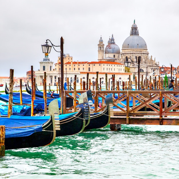 Foto gôndolas no cais e a igreja de santa maria della salute ao fundo, veneza, itália