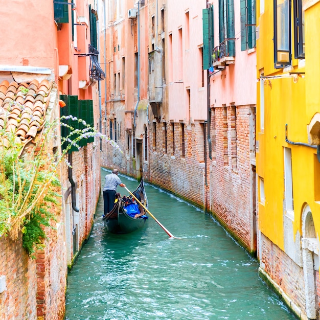 Gondoleiro na gôndola em um canal em Veneza, Itália