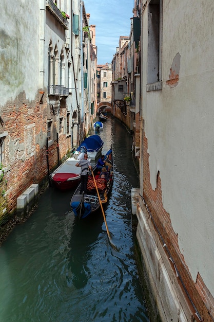 Gondoleros en los canales de Venecia llevan turistas