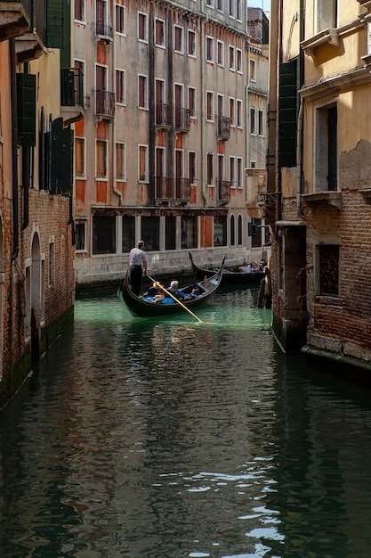 Gondoleros en los canales de Venecia llevan turistas