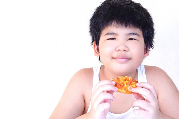 Un gordo con camiseta blanca disfruta comiendo pizza