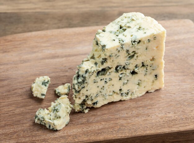 Gorgonzola-Käse mit Stücken über Holzbrett