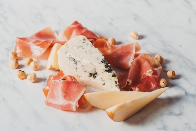 Gorgonzola- und Prosciutto-Scheiben mit Birne. Leckere Vorspeise