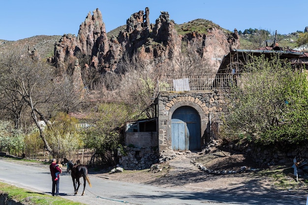 Goris Armenia Hombre con un niño en los brazos y un burro en la calle de un antiguo pueblo de Goris