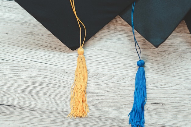 Gorra de graduación negra Nivel universitario colocado en una mesa de madera concepto de graduación