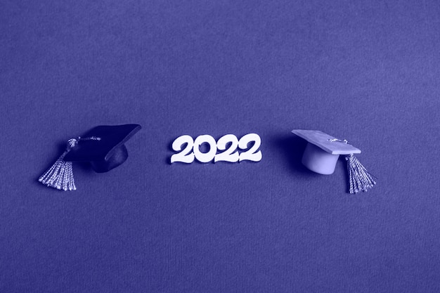 Gorra de graduación y números 2022 en un fondo muy peri, primer plano con espacio de copia. concepto de educación médica.