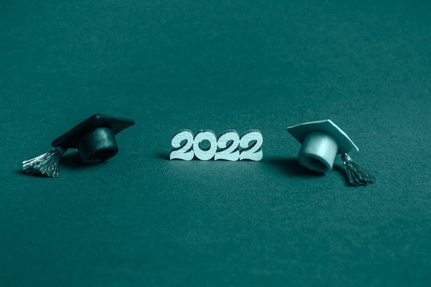 Gorra de graduación y números 2022 sobre fondo azul, cerrar con espacio de copia. Concepto de educación médica.