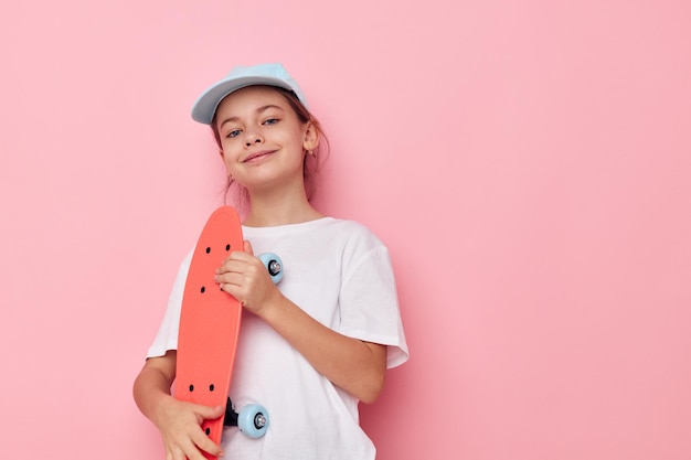 Gorra de niña en camiseta blanca monopatín infancia inalterada